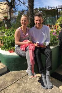 Edith und Jens Wittkamp sitzen im Garten vor ihrem Yoga Übungsraum in portugiesischen historischen Innenhof.