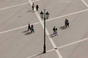 Praça do Comercio, Lissabon Menschen gehen spazieren, in der Mitte eine antike Laterne. Das Foto ist eine Luftaufnahme.